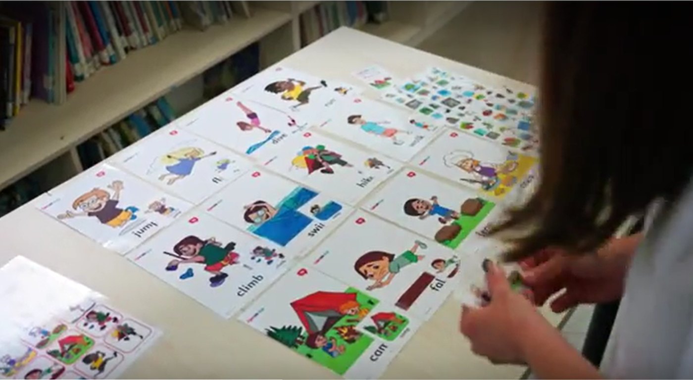 A child laying out picture cards during a Speak-Up lesson