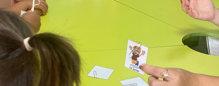 Балалар сабақ кезінде Speak-Up суретті карточкаларына қол созып отыр